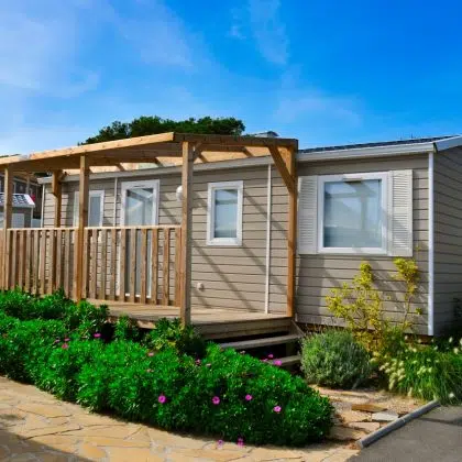 a nice mobile home with a wooden veranda in a campsite